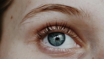 Nahaufnahme eines blauen Auges mit detaillierten Wimpern