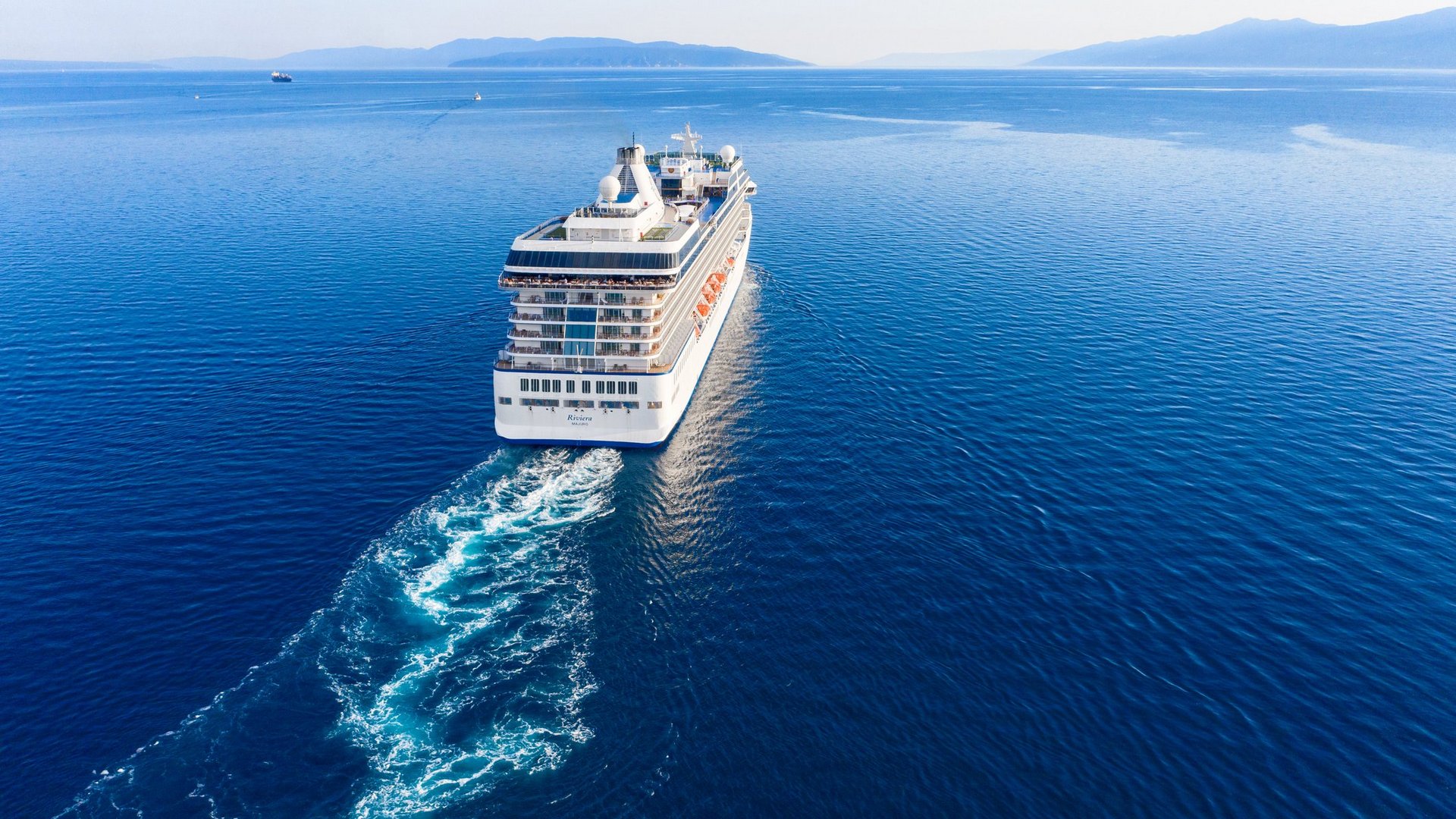 Das Foto zeigt ein Kreuzfahrtschiff auf blauem Wasser.