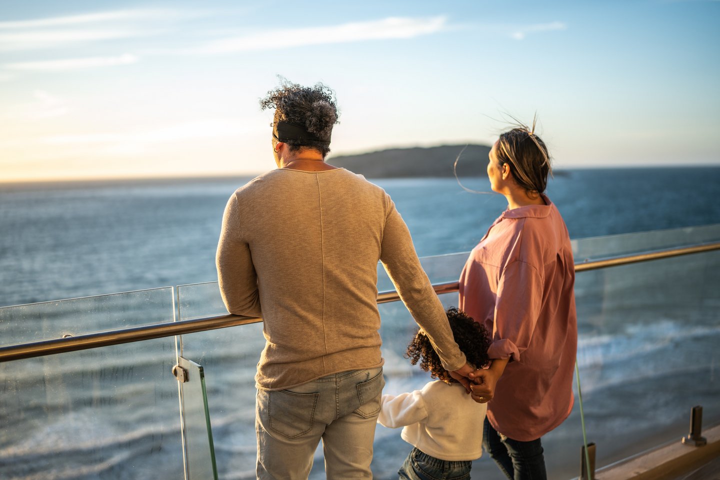 Das Foto zeigt eine Familie an der Reling eines Kreuzfahrtschiffs.