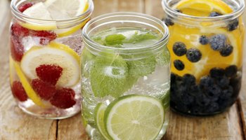 Das Foto zeigt drei Gläser mit Fruit Infused Water und Früchten.