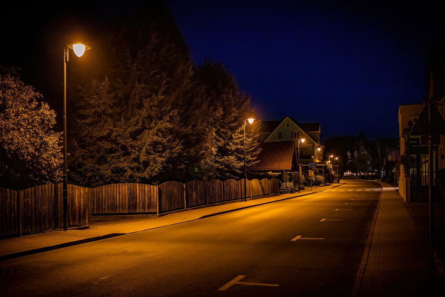 Das Foto zeigt eine Straße bei Nacht mit Straßenlaternen