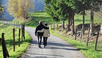 paziergang eines älteren Paares in ländlicher Umgebung als aktive Bewegung