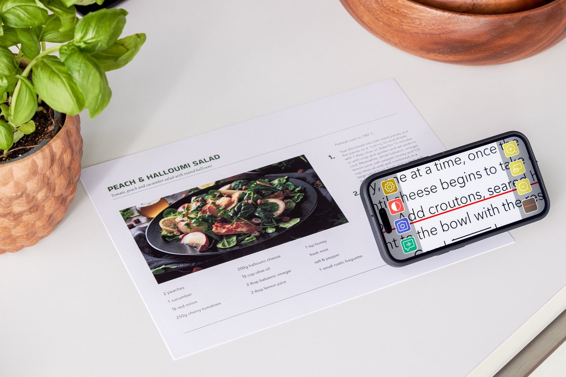 Das Bild zeigt ein iphone, andem optaro motniert ist, auf einem Tisch. Es wird ein Rezept vergrößert