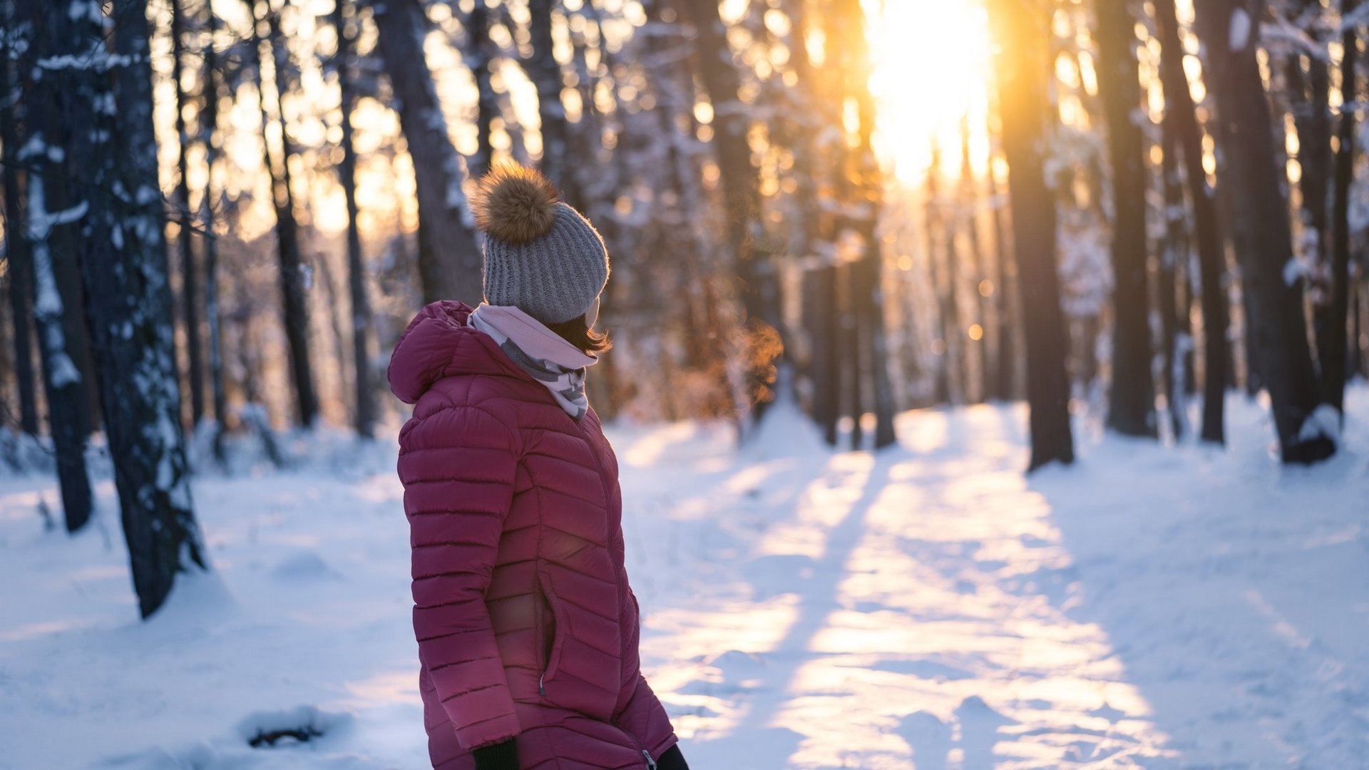 Das Foto zeigt eine Frau beim Winterspaziergang in der Sonne.